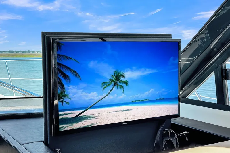 Slide: The Image of Flat-screen TV on 2020 Riviera 4800 Sport Yacht, displaying tropical beach scene. - 37
