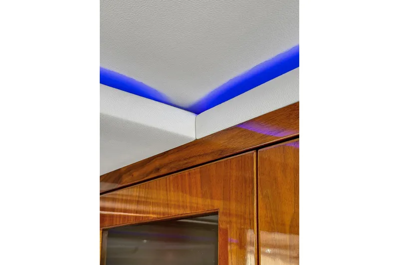 Slide: The Image of Interior detail of 2020 Riviera 4800 Sport Yacht with wood finish and blue LED lighting. - 50