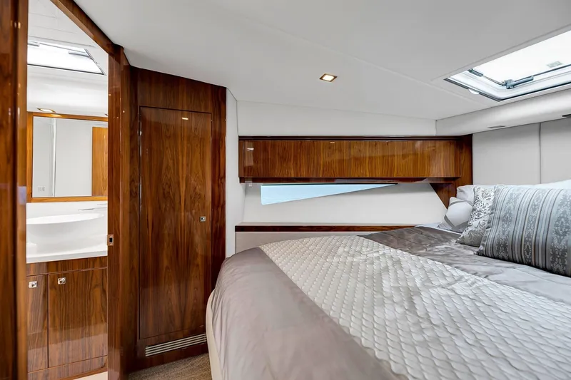 Slide: The Image of Luxurious bedroom interior of 2020 Riviera 4800 Sport Yacht with elegant wood finishes. - 52