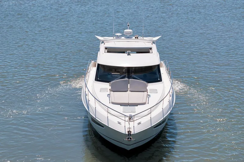 Slide: The Image of 2020 Riviera 4800 Sport Yacht cruising on calm waters, front view. - 9