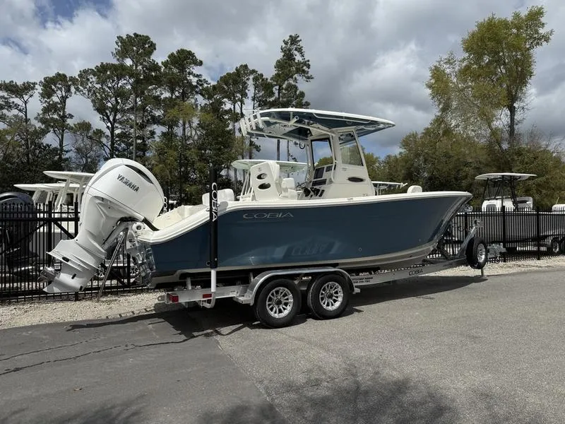 Slide: The Image of 2025 Cobia 240 Center Console boat on trailer, parked outdoors, with Yamaha engine. - 3