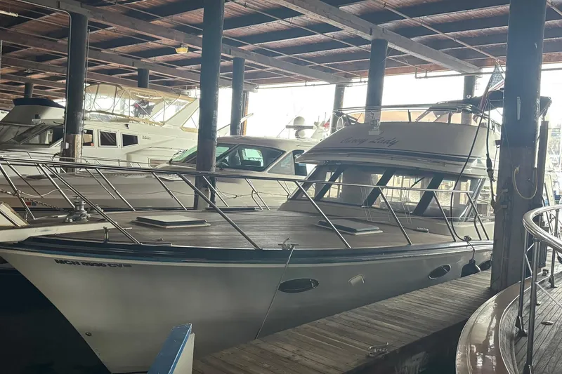 The Image of Boat docked in marina, surrounded by other vessels, under wooden roof. - 1