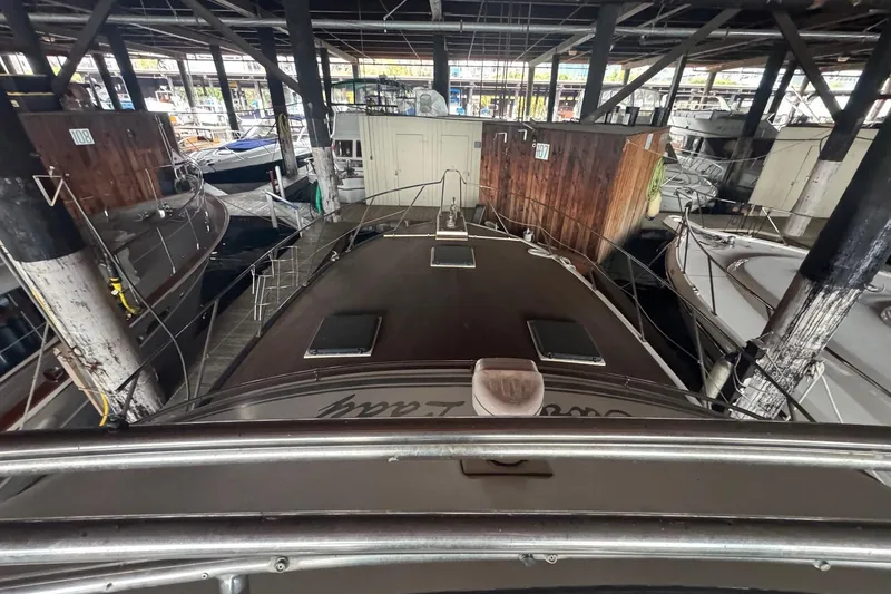Slide: The Image of 1990 Symbol 53 Sedan yacht docked in a covered marina with surrounding boats. - 4