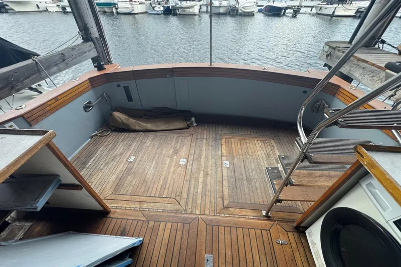 Slide: The Image of Wooden deck of a boat with marina view, featuring stairs and storage compartments. - 5