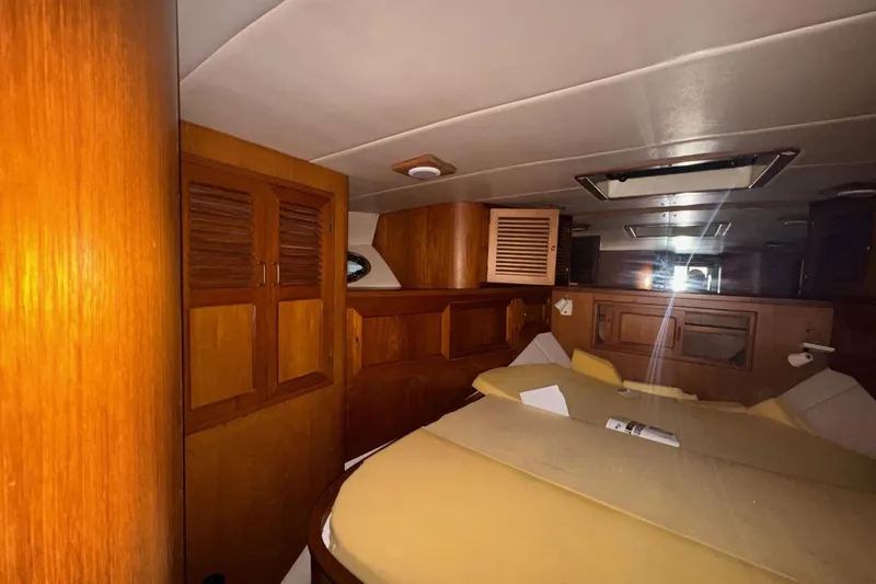 Slide: The Image of Interior of a 1990 Symbol 53 Sedan yacht with wooden cabinetry and a cozy sleeping area. - 9