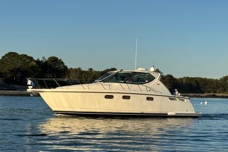 The Image of 2008 Tiara Yachts 3900 Sovran cruising on calm water near a forested shoreline. - 0