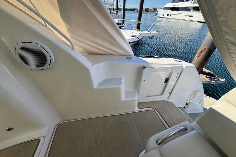 Slide: The Image of 2008 Tiara Yachts 3900 Sovran interior, featuring seating and speaker, docked by the water. - 17