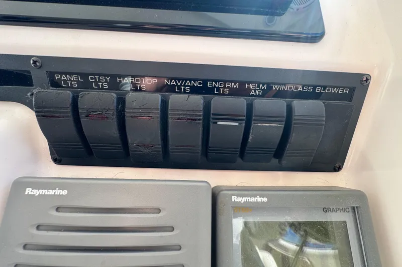 Slide: The Image of Control panel of a 2008 Tiara Yachts 3900 Sovran with labeled switches and Raymarine displays. - 32