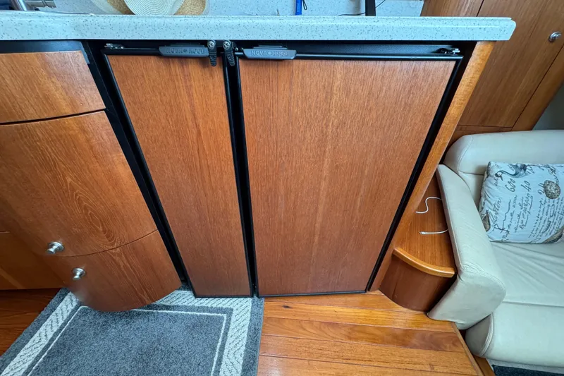 Slide: The Image of 2008 Tiara Yachts 3900 Sovran interior with wooden cabinetry and compact refrigerator. - 43