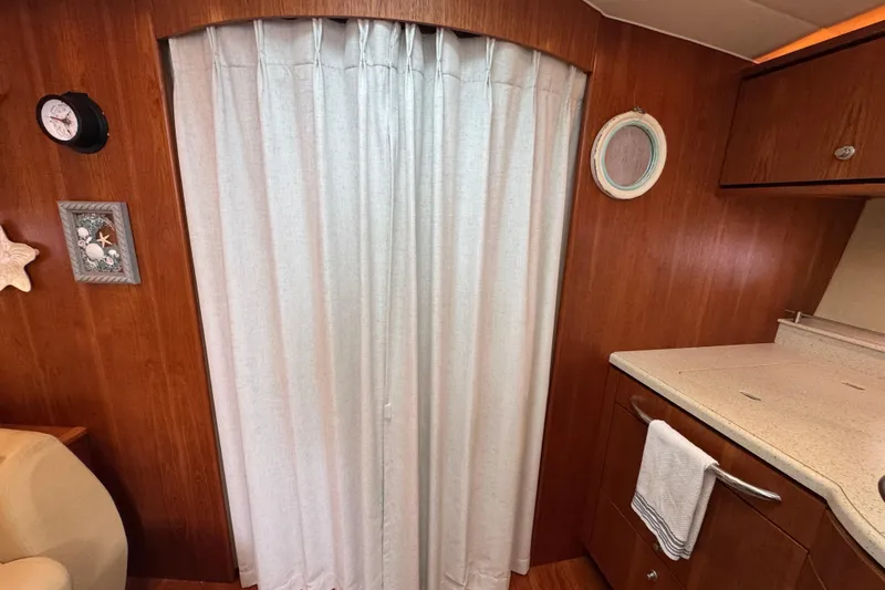 Slide: The Image of 2008 Tiara Yachts 3900 Sovran interior with wood cabinetry, curtain, and nautical decor. - 50