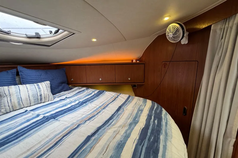 Slide: The Image of Cozy cabin interior of 2008 Tiara Yachts 3900 Sovran with striped bedding and wood paneling. - 53