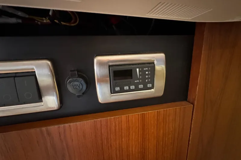 Slide: The Image of Control panel on 2008 Tiara Yachts 3900 Sovran, featuring switches and a 12V outlet. - 54