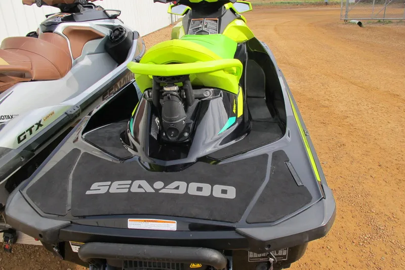 Slide: The Image of 2019 Sea-Doo GTI SE 155 jet ski, vibrant green and black design, parked on dirt. - 2