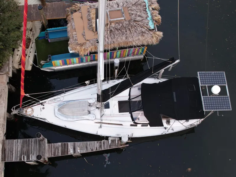 Slide: The Image of 1989 Canadian Sailcraft CS40 sailboat docked beside a colorful houseboat, aerial view. - 1