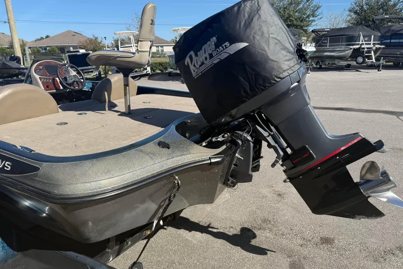 Slide: The Image of 2002 Ranger 185 VS boat with covered outboard motor, beige seating, and steering console. - 9
