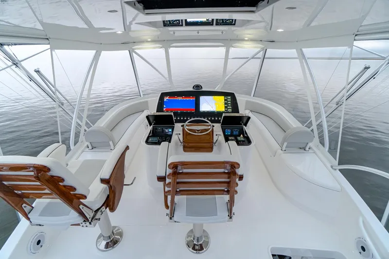 Slide: The Image of 2026 Viking 54 Convertible yacht helm with advanced navigation systems and luxurious seating. - 15