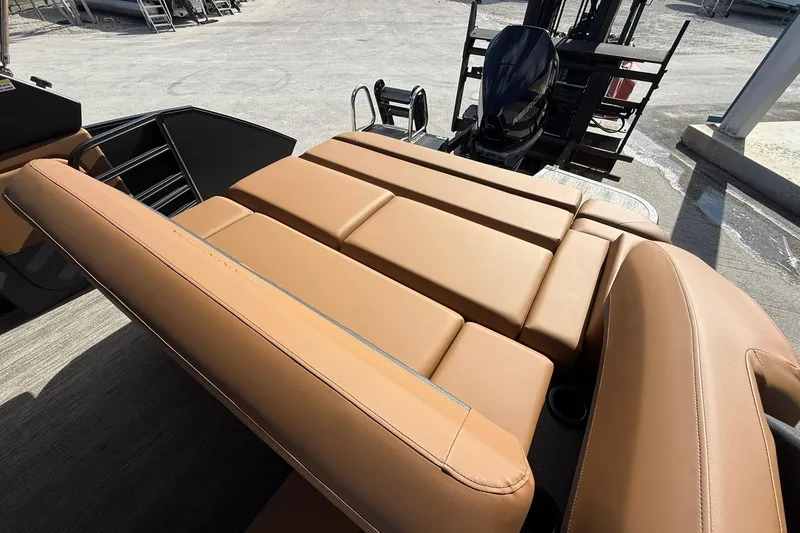 Slide: The Image of 2026 Bennington 26 M Swingback boat with tan leather seating and outboard motor. - 24