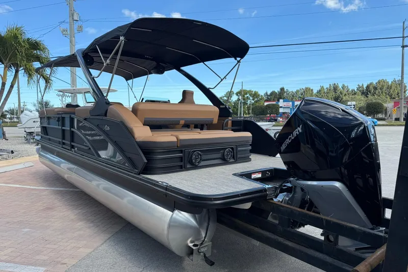 Slide: The Image of 2026 Bennington 26 M Swingback pontoon boat with Mercury outboard motor, parked outdoors. - 6