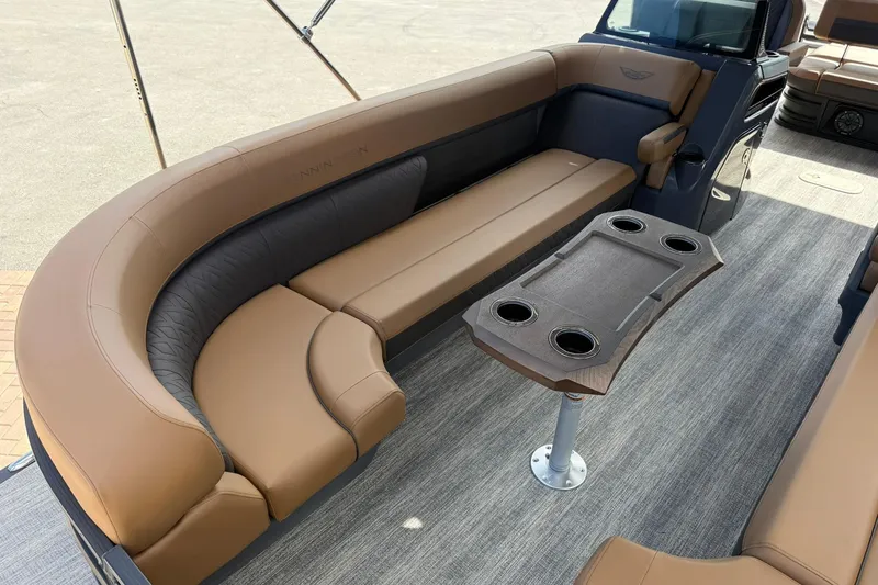 Slide: The Image of 2026 Bennington 26 M Swingback boat interior with tan seating and table. - 9