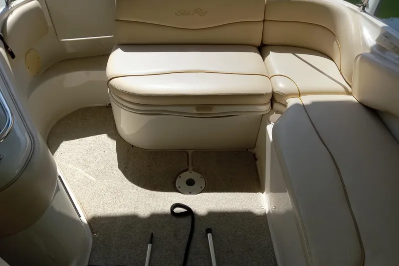 Slide: The Image of Interior seating of a 2001 Sea Ray 240 Sundeck boat, featuring beige upholstery. - 7