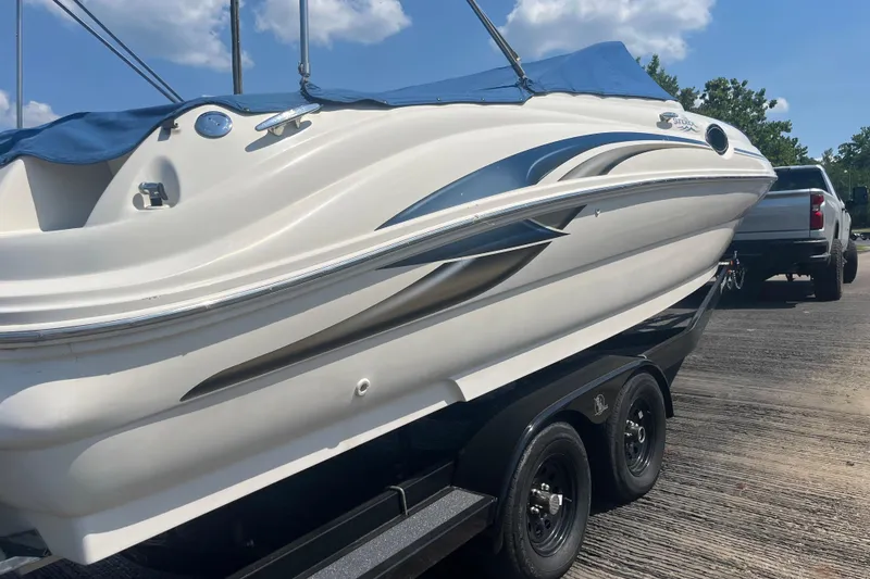 Slide: The Image of 2001 Sea Ray 240 Sundeck boat on trailer, blue cover, sunny day. - 9