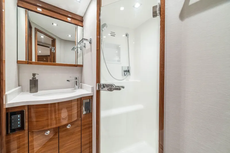 Slide: The Image of Luxurious bathroom in 2026 Viking 64 Convertible yacht with modern fixtures and wood accents. - 17