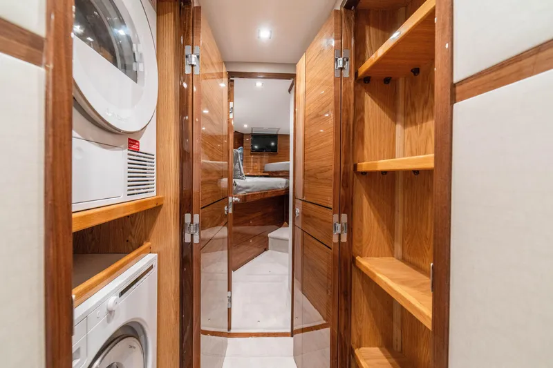 Slide: The Image of Interior of 2026 Viking 64 Convertible yacht with wood finishes and laundry appliances. - 20