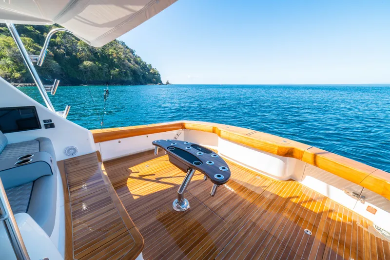 Slide: The Image of Luxurious 2026 Viking 64 Convertible yacht deck with ocean view and fishing setup. - 25
