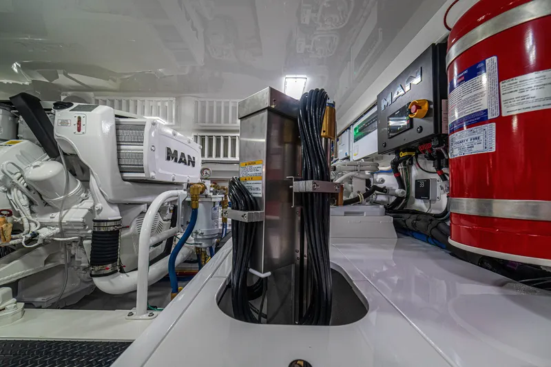 Slide: The Image of Engine room of 2026 Viking 64 Convertible yacht with MAN engines and safety equipment. - 54