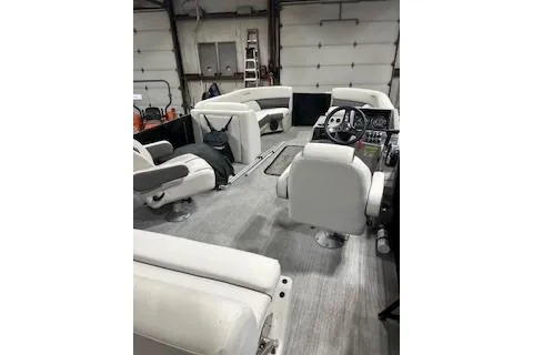 Slide: The Image of 2023 Harris Cruiser 230 interior with white seating in a garage setting. - 19