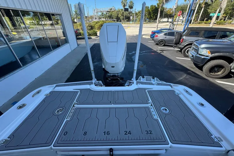 Slide: The Image of 2024 Crevalle 26 HCO boat with spacious deck and modern design in a parking lot. - 11