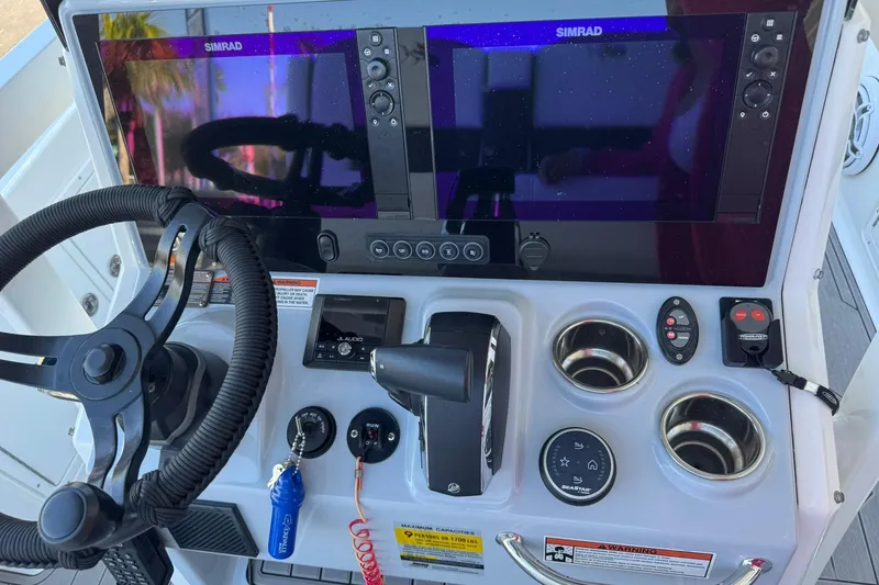 Slide: The Image of 2024 Crevalle 26 HCO boat dashboard with dual Simrad displays and controls. - 21