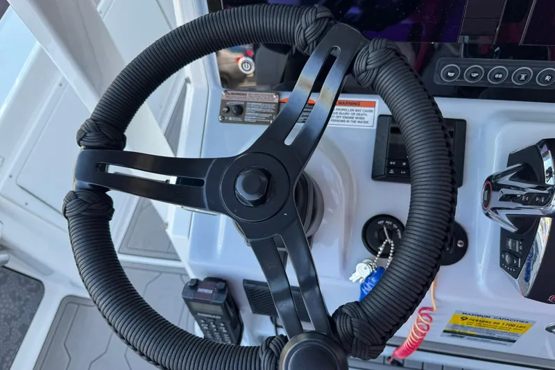 Slide: The Image of Steering wheel and controls of 2024 Crevalle 26 HCO boat cockpit. - 24