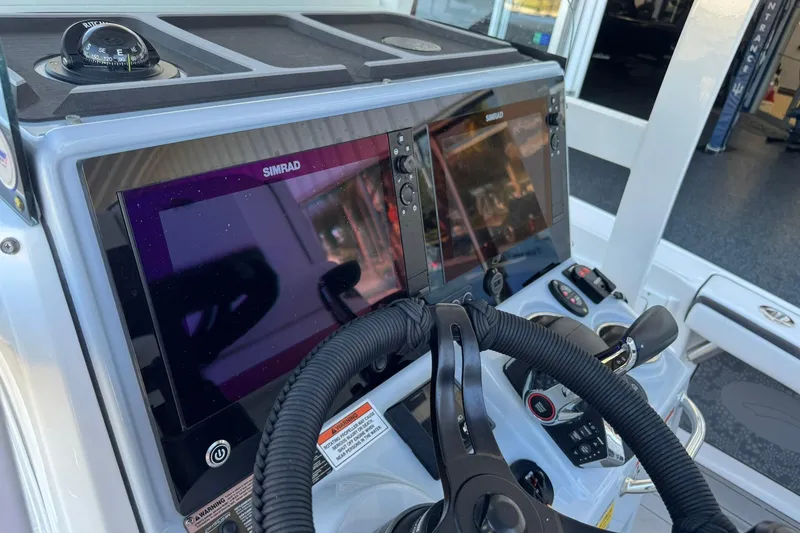 Slide: The Image of 2024 Crevalle 26 HCO boat dashboard with Simrad displays and steering wheel. - 27