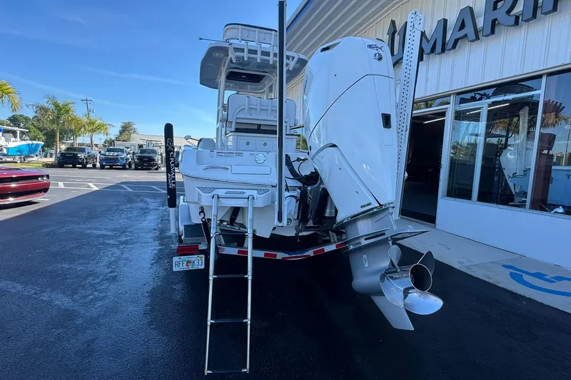 Slide: The Image of 2024 Crevalle 26 HCO boat with powerful outboard motor, parked outside a marine dealership. - 3