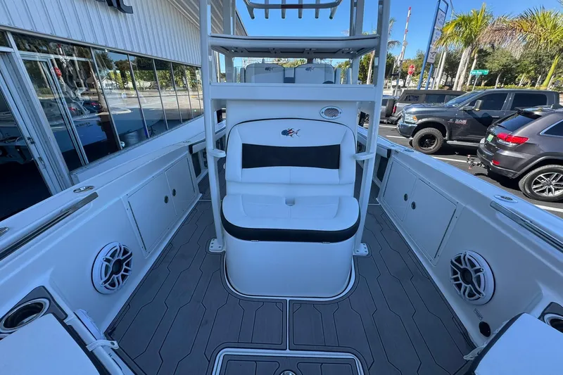 Slide: The Image of 2024 Crevalle 26 HCO boat interior with seating and speakers, parked outdoors. - 35