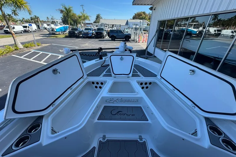 Slide: The Image of 2024 Crevalle 26 HCO boat with open storage compartments, docked outdoors. - 38