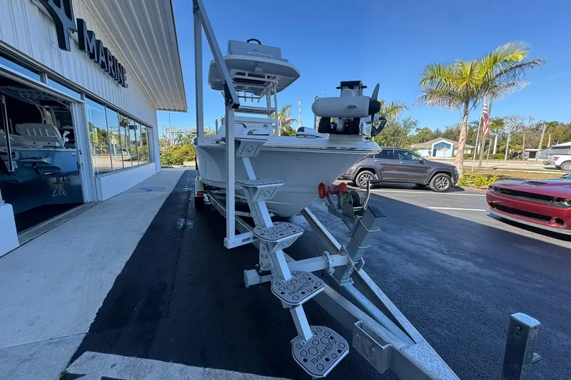 Slide: The Image of 2024 Crevalle 26 HCO boat on trailer outside marine dealership, sunny day. - 8