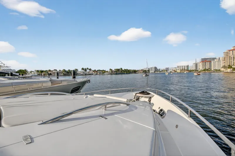 Slide: The Image of 2009 Horizon Flybridge yacht on calm waters with cityscape and blue sky. - 12
