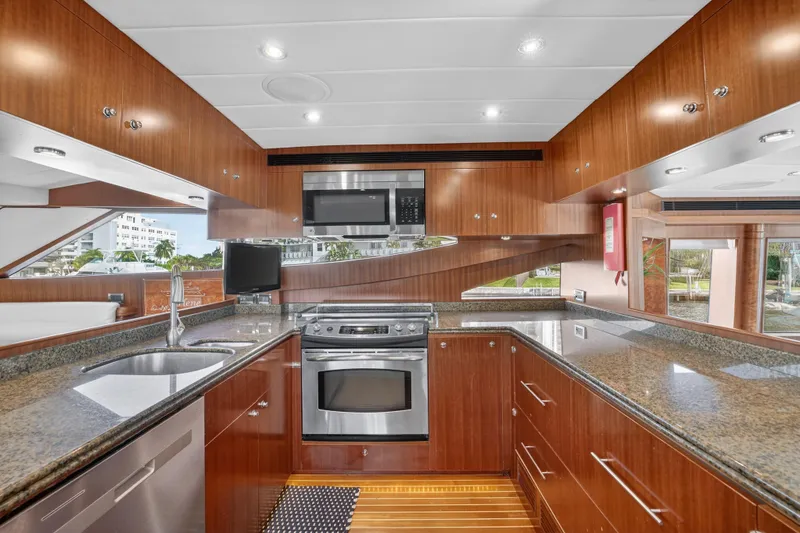 Slide: The Image of Luxurious 2009 Horizon Flybridge yacht kitchen with modern appliances and sleek wood cabinetry. - 16