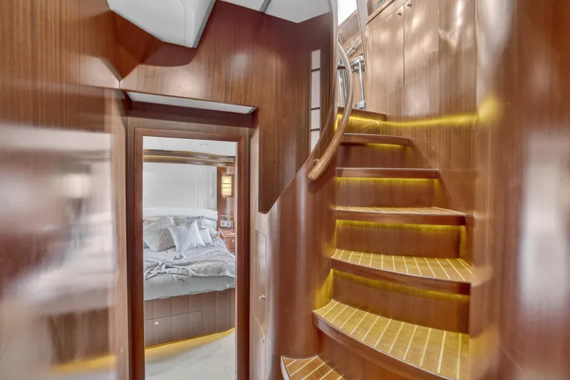 Slide: The Image of Luxurious 2009 Horizon Flybridge yacht interior with wooden staircase and cozy bedroom. - 19