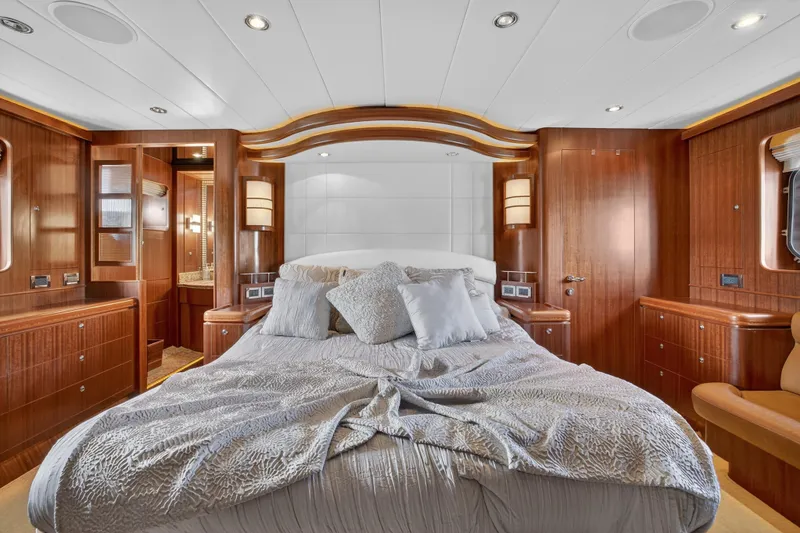 Slide: The Image of Luxurious 2009 Horizon Flybridge yacht bedroom with elegant wood paneling and plush bedding. - 20