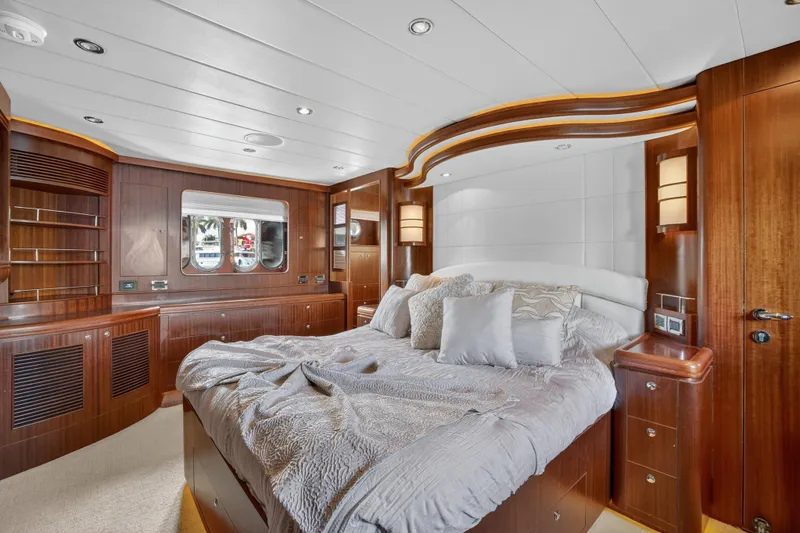 Slide: The Image of Luxurious 2009 Horizon Flybridge yacht bedroom with elegant wood paneling and plush bedding. - 21