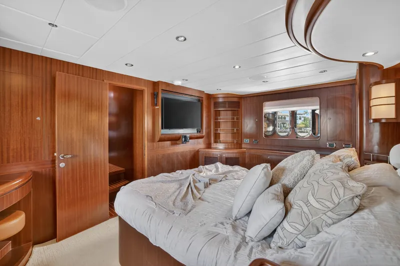 Slide: The Image of Luxurious 2009 Horizon Flybridge yacht bedroom with wood paneling and plush bedding. - 22