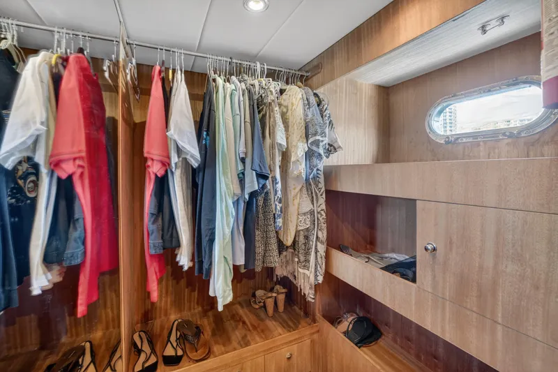 Slide: The Image of Closet interior on 2009 Horizon Flybridge yacht with clothes and shoes neatly organized. - 24