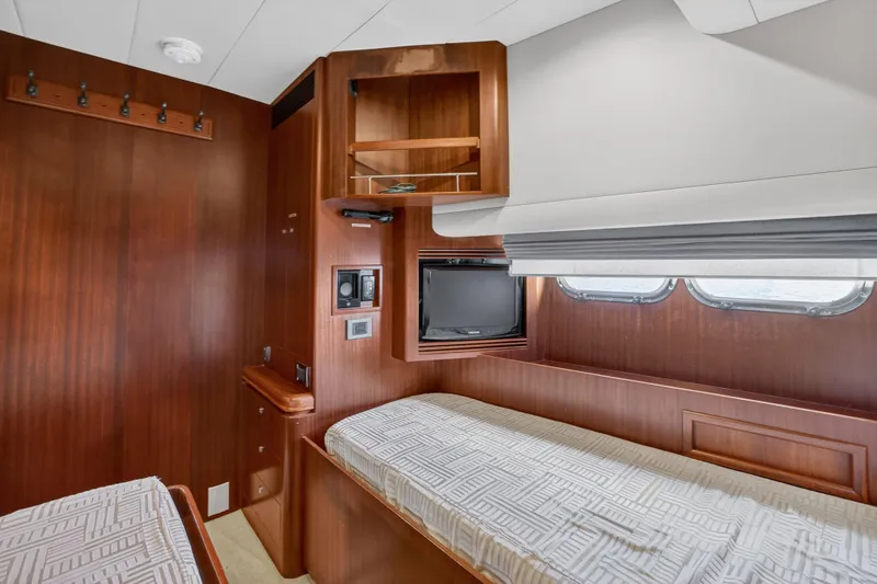 Slide: The Image of Luxurious 2009 Horizon Flybridge yacht cabin with wooden interior and twin beds. - 29