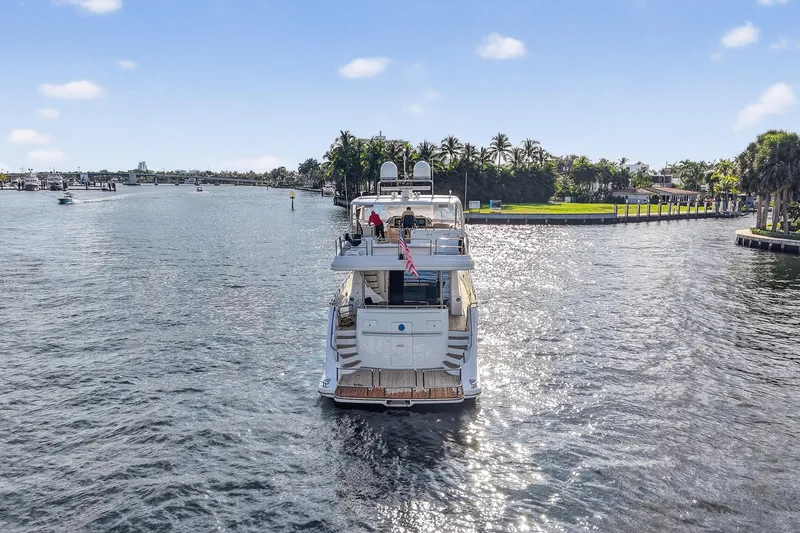 Slide: The Image of Luxury 2009 Horizon Flybridge yacht cruising on a sunny waterway, surrounded by lush greenery. - 5