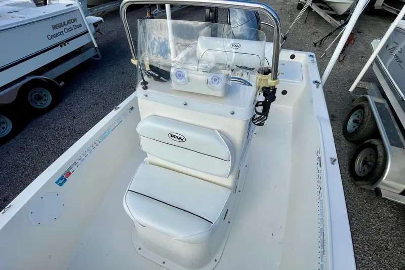 Slide: The Image of 2013 Key West 172 SE boat interior with console and seating, parked on gravel. - 12