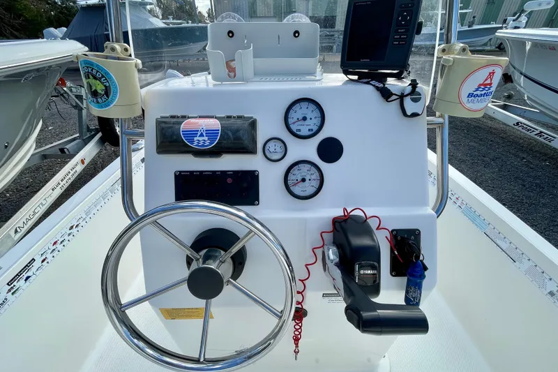 Slide: The Image of 2013 Key West 172 SE boat dashboard with steering wheel, gauges, and controls. - 14