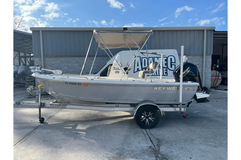 The Image of 2022 Key West 1720 Sportsman boat on trailer, parked outside a marine facility. - 0